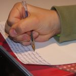 Personne étudiant son cours sur une table noire.